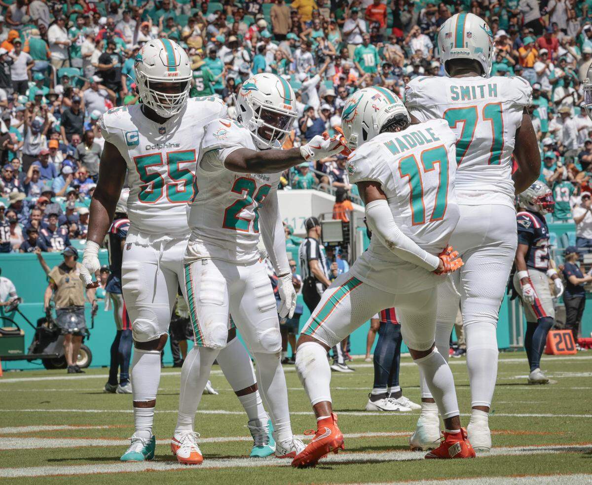 Miami Dolphins running back De'Von Achane (28) celebrates his touchdown with wide receiver Jaylen Waddle (17) and teammates in the second half against the New England Patriots during an NFL football game at Hard Rock Stadium in Miami Gardens, Florida, on Sunday, September 14, 2025. 