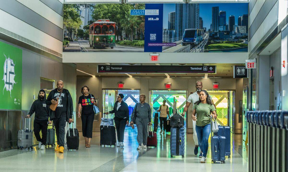 Passengers walked out of the terminal to take the train to the rental building, at Miami International Airport ahead of the Holidays in Miami, on Friday, November 21, 2025.