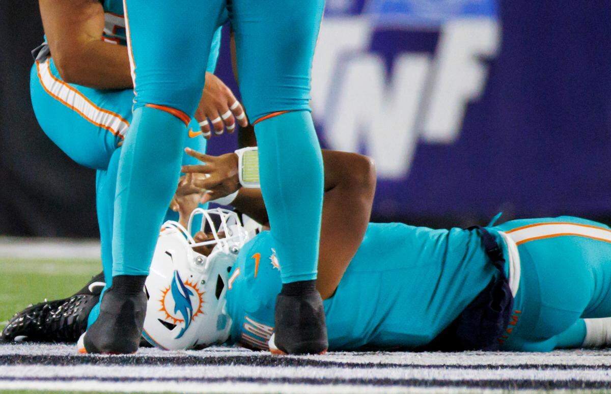 El quarterback de los Miami Dolphins, Tua Tagovailoa (1), yace tirado en el terreno de juego tras ser capturado atrás de la línea por el tackle defensivo de los Cincinnati Bengals, Josh Tupou (68), durante el segundo cuarto del partido de football de la NFL en el Paycor Stadium, el jueves 29 de septiembre de 2022, en Cincinnati, Ohio.
