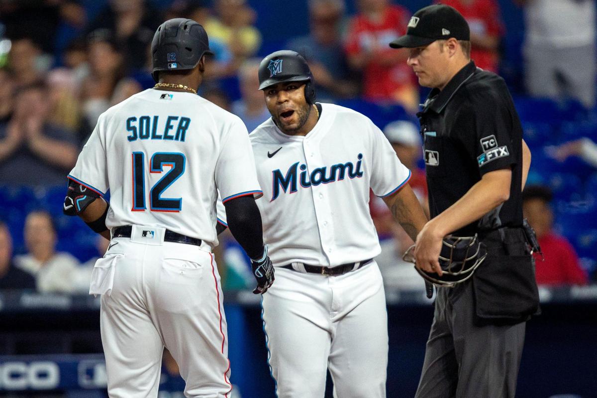 Miami Marlins base runner Jorge Soler (12) reacts with teammate Jesus Aguilar (99) after both players scored fter a Soler home run on a fly ball to left center field during the first inning of an MLB game against the Seattle Mariners at loanDepot park in the Little Havana neighborhood of Miami, Florida, on Friday, April 29, 2022.