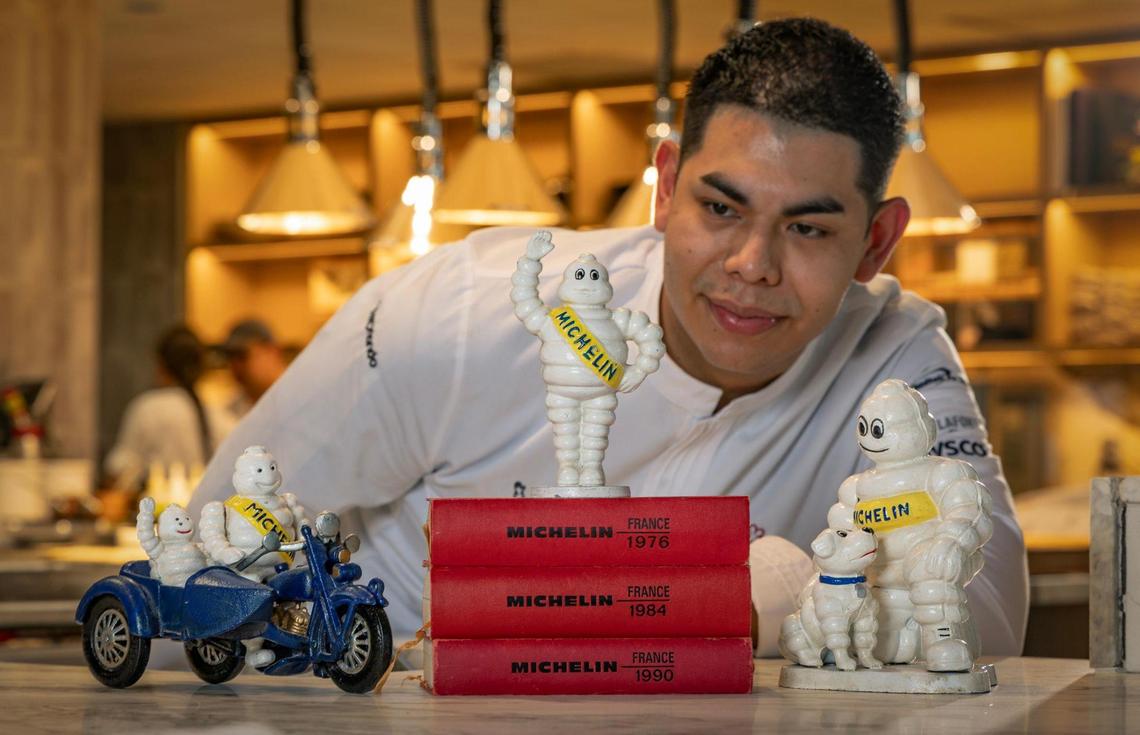 Chef David Brito shows off vintage Michelin memorabilia on display on the Chef’s Counter at MAASS restaurant, which was awarded a Michelin star in April.