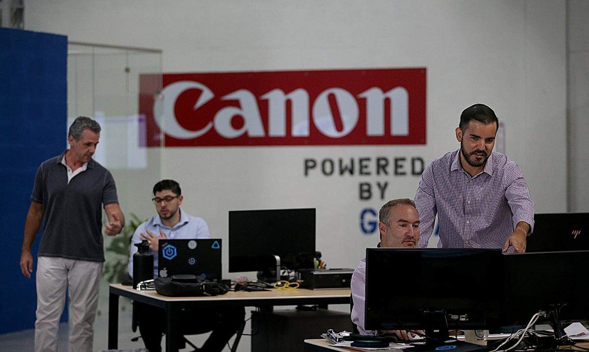 Mauricio Del Solar, VP GOJA Bolivia (foreground, left), and Sebastian Gonzalez, VP Ecommerce and Amazon Strategy, discuss work in a big open room at the tech company’s Miami offices on Tuesday, October 9, 2018.