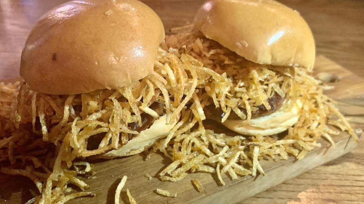 La Flaca Plant-based Frita is served with onions, potato springs and ketchup. It’s topped with a “vegan bun.”