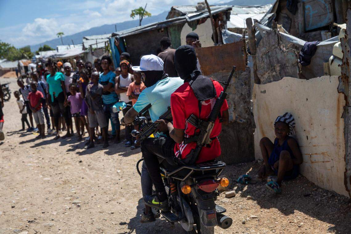 G9 coalition gang members ride a motorcycle through a market in Port-au-Prince, Haiti, on Oct. 6, 2021. Jimmy Cherizier, aka ‘Barbecue,’ a former policeman who leads the G9 gang coalition, has taken control of the port district, gaining a stranglehold on the country’s economy.
