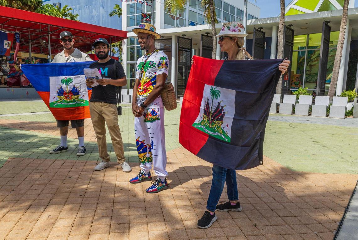 Julian Rodriguez and Johanna Sherry hold a couple of Haitian Flag on Saturday May 18, 2025, during a HistoryMiami Museum Little Haiti History and Culture Walk lead by Jean Dondy Cidelca (center) who talked about the celebration of Haiti’s Flag Day, on May 18, in Miami.