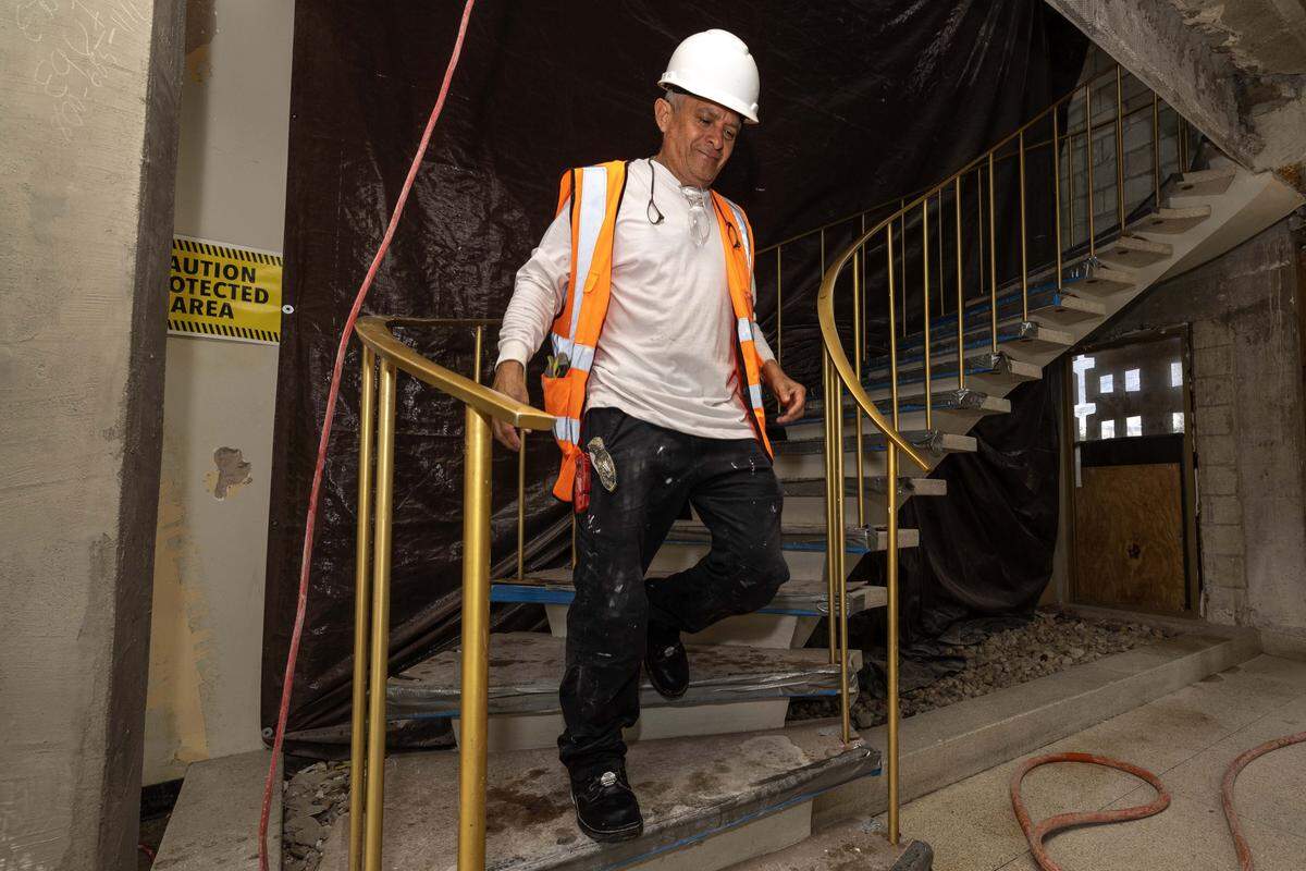 A construction worker walks down the original stairway at Miami International Airport’s new private terminal on Wednesday, July 23, 2025, in Miami, Fla.