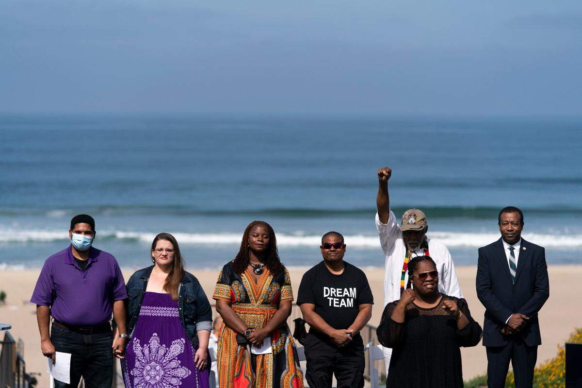 Anthony Bruce, from left, a great-great grandson of Charles and Willa Bruce, wife, Sandra, Kavon Ward, founder of Justice for Bruce’s Beach, Derrick Bruce, great grandson of Charles and Willa Bruce, Chief Duane Yellow Feather Shepard and Mitch Ward attend a dedication ceremony in Manhattan Beach, Calif., Wednesday, July 20, 2022. (AP Photo/Jae C. Hong)