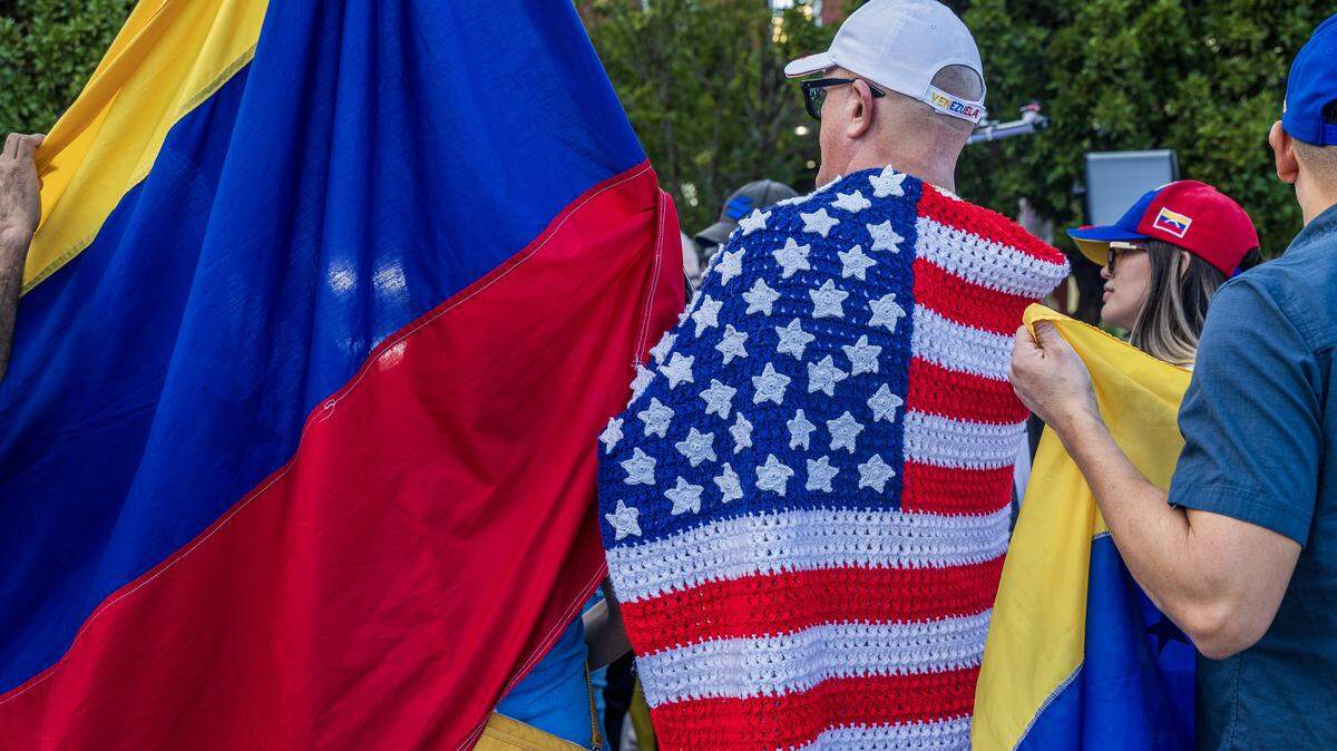 Attendees including Victor Gimenez (left) displayed Venezuelan and American flags, during a celebration rally outside of El Arepazo in Doral, Florida, a day after the United States attacked Venezuela and captured leader Nicolás Maduro and his wife Cilia Flores, on January 04, 2026.