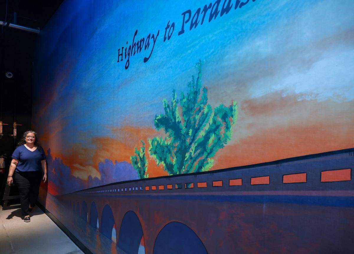Maya Palazon walks along side the new mural at FreshCo Fish in Doral, Florida as she and her husband opened their new 127-seat restaurant on Wednesday, December 24, 2025.