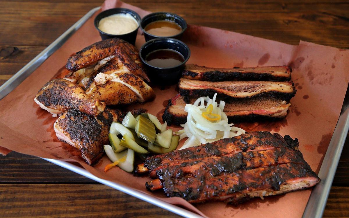 A display of delicious barbecue meats, including homemade sauces, spice rubbed chicken, spare ribs with a jerk rub, pickled onions and slow cooked brisket from the menu of the recently opened pop-up The Drinking Pig.