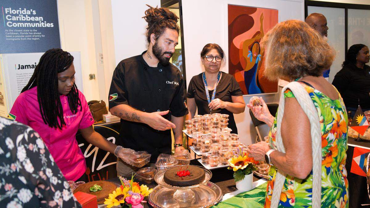 Visitors at Island SPACE Caribbean Museum’s Rum Cake and Caribbean Black Cake Fest sample cake from Guyanese bakers.