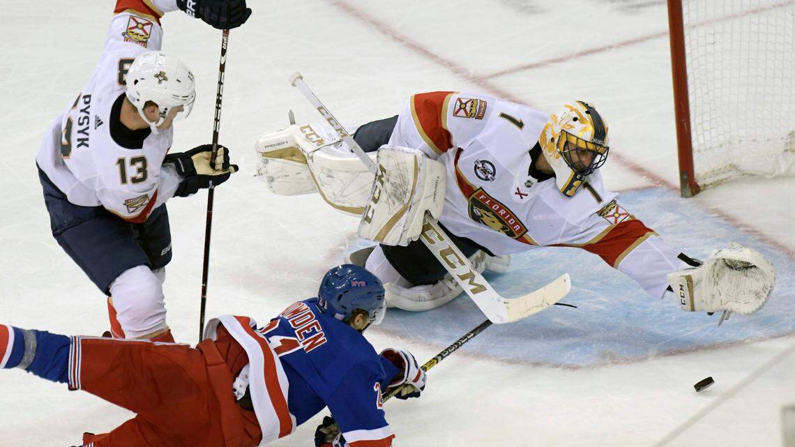 Florida Panthers goaltender Roberto Luongo (1) dives for the puck as New York Rangers center Brett Howden (21) attempt to get his stick on it as Panthers defenseman Mark Pysyk (13) looks on during the third period of an NHL hockey game Saturday, Nov, 17, 2018, at Madison Square Garden in New York. The Rangers won 4-2.(AP Photo/Bill Kostroun)