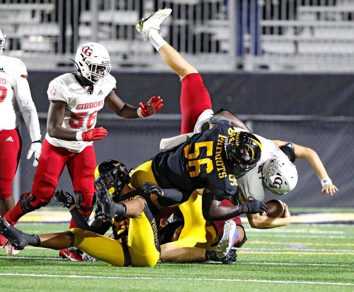 American Heritage defensive line Omarion Abraham (56) tackles Cardinal Gibbons Chiefs quarterback Michael Merdinger during the football game on Friday, September 29, 2023 at American Heritage HS in Plantation. Andrew Uloza / for Miami Herald
