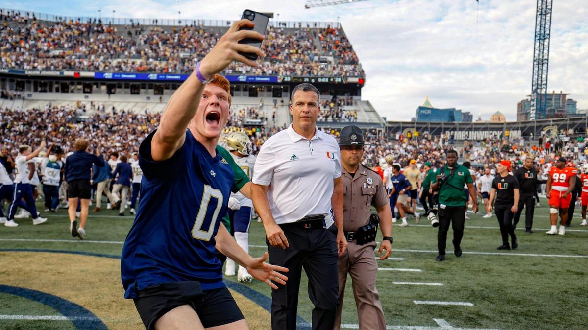 A Georgia Tech football fan takes a selfie in front of Miami Hurricanes head coach Mario Cristobal as the Yellow Jackets celebrate the defeat of the Canes in an NCAA game at Bobby Dodd Stadium at Hyundai Field in Atlanta, Georgia on Saturday, November 9, 2024.