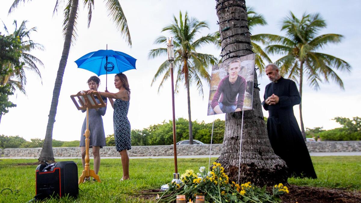 A woman sings a song to conclude a vigil to honor the life of tourist Dustin Wakefield, at Lummus Park near Ocean Drive and 14th Street in Miami Beach, Florida, on Tuesday, August 31, 2021. Wakefield, 21, a tourist from Castle Rock, Colorado, was dining on Ocean Drive when he was fatally shot.
