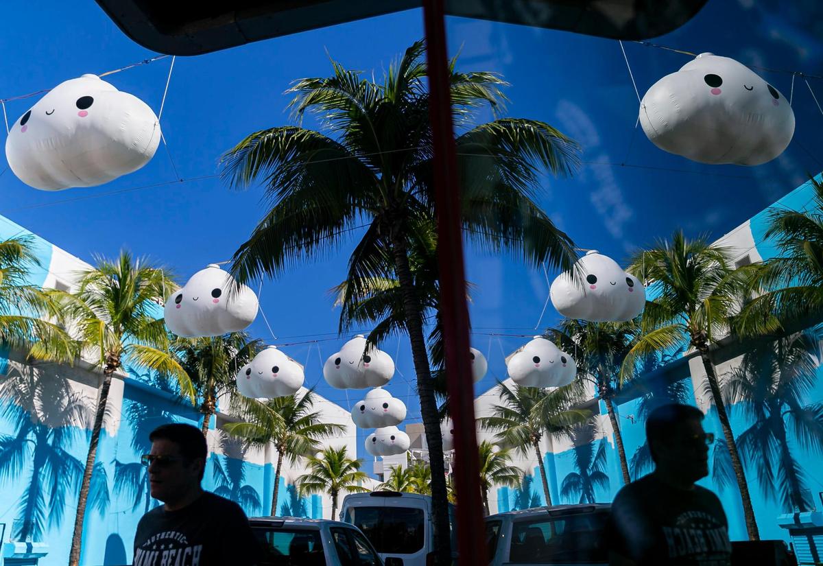 Un peatón camina frente a Little Cloud Sky de FriendsWithYou cerca de Washington Avenue y Española Way en Miami Beach, Florida, el martes 30 de noviembre de 2021.