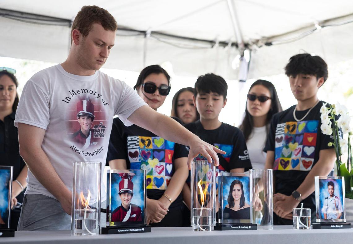 Ryan Schachter, brother of Alexander Schachter, helps light the candle of Carmen Schentrup during the ‘Forever in Our Hearts’ commemoration event outside of the Eagles’ Haven Wellness Center on Friday, Feb. 14, 2025, in Coral Springs, Fla. The event aims to honor the 17 lives lost during the Marjory Stoneman Douglas High School shooting in 2018 and their families.