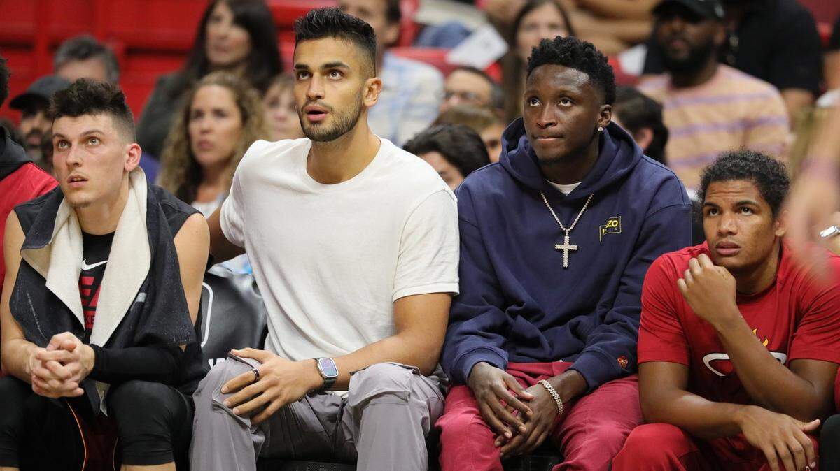 Miami Heat guard Tyler Herro (14), Miami Heat center Omer Yurtseven (77), guard Victor Oladipo (4) and guard Dru Smith (9) watch the game against the Boston Celtics from the bench at FTX Arena in Miami on Friday, October 21, 2022.