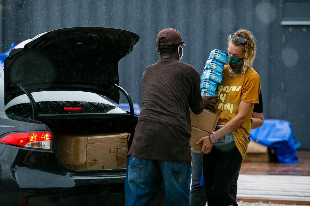 Ernest Rowell, 49, and Emily Milton, 27, load up a vehicle with personal protective equipment during a drive thru distribution event in Miami’s Overtown neighborhood on Saturday, July 25, 2020. The Miami Foundation, Health Foundation of South Florida, Florida Blue Foundation and partners put nearly 70,000 units of PPE into the hands of 42 nonprofit organizations that got a three-month supply each to help fight the spread of COVID-19.