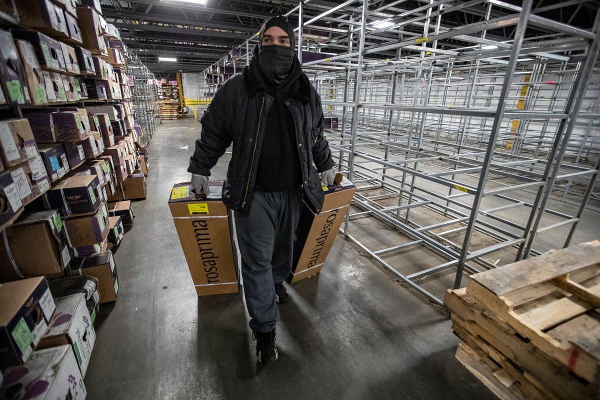Eric Mesa pulls boxes of flowers stored in the cooler at Florida Beauty Flora Transportation warehouse in Miami 