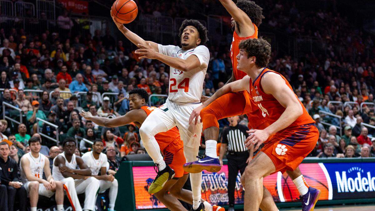 Miami Hurricanes guard Nijel Pack (24) lays up the ball while chased by University of Clemson guard Dillon Hunter (2) and center PJ Hall (24) during the second half of an NCAA basketball game at the Watsco Center in Coral Gables, Florida, on Wednesday, January 3, 2024. He may miss the Jan. 10 game vs. Louisville with an ankle sprain.