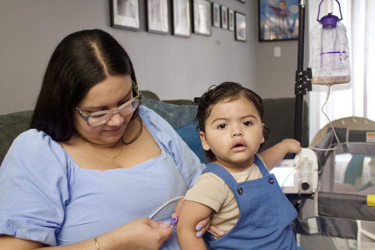 Lilchrist McCoy Alcantara connects Bryson’s feeding tube before nap time. 