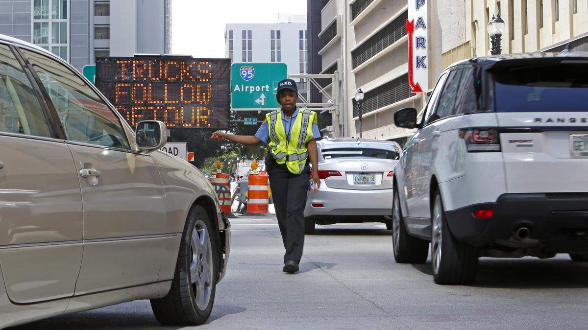The City of Miami Police traffic control specialist Taquell Pugh directing traffic at the intersection of SE 2nd Street and SE 3rd Avenue in downtown Miami on Thursday, April 12, 2018.