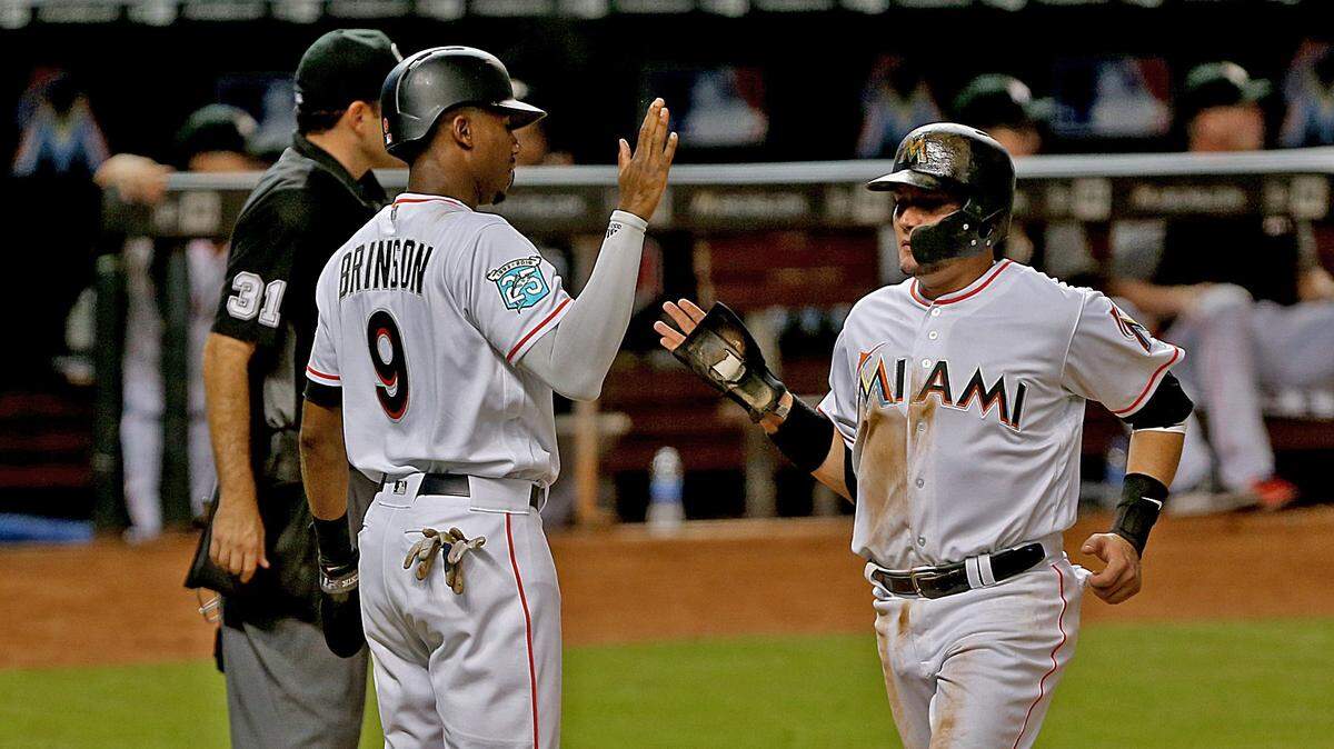 The Marlins’ Lewis Brinson and  Miguel Rojas score two runs in the sixth inning as the Miami Marlins host the Washington Nationals on Monday, September 17, 2018.
