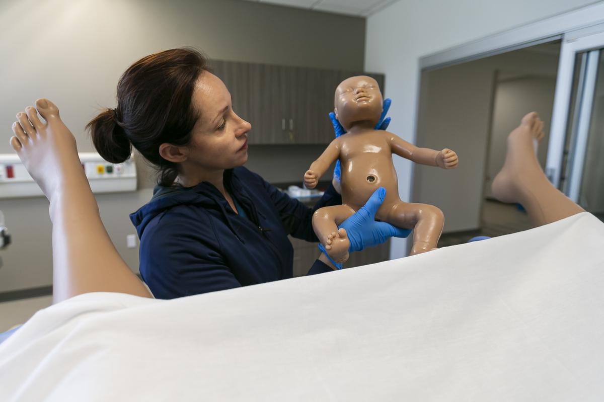 Shanti Fernandez, 32, a recent nursing school graduate, performs a checkup on HAL, a medical mannequin, at the new Center for Learning, Innovation and Simulation at Miami Dade College’s Medical Campus.