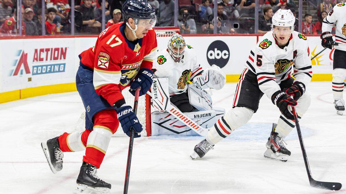 Florida Panthers center Evan Rodrigues (17) looks to pass as Chicago Blackhawks defenseman Connor Murphy (5) defends in the first period of their NHL game at Amerant Bank Arena on Saturday, Feb. 1, 2025, in Sunrise, Fla.