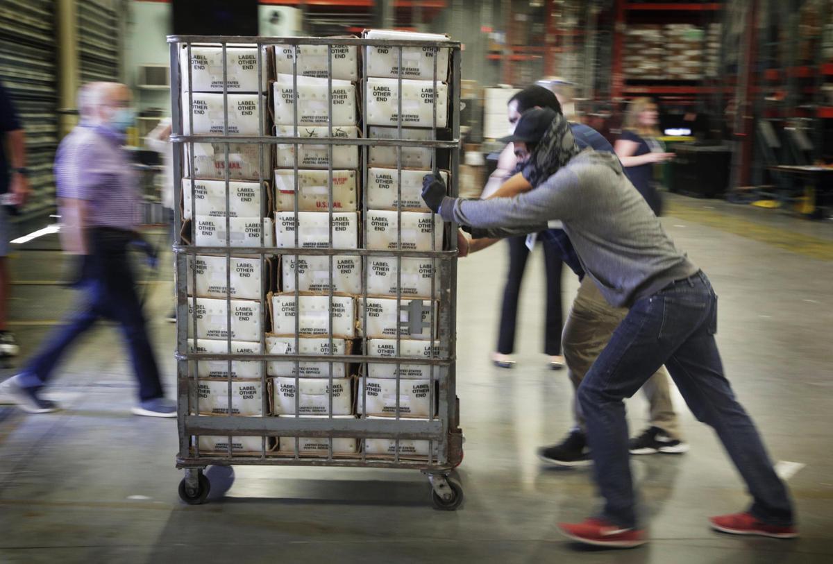 Voting is underway in Florida. Absentee ballots went out last week in Miami-Dade. Here, workers load carts filled with ballots onto a waiting USPS truck at the Miami-Dade County Elections Department in Doral.