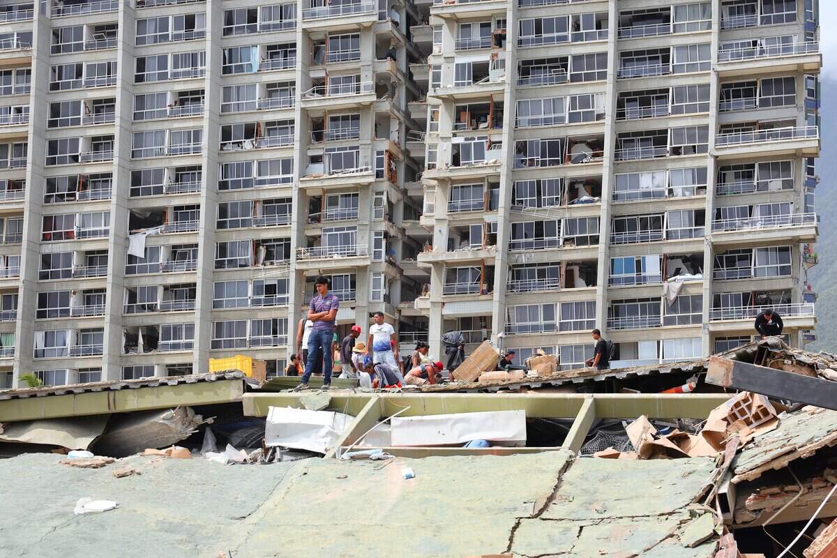 People search for victims amid buildings on June 25, 2026 in La Guaira, Venezuela.