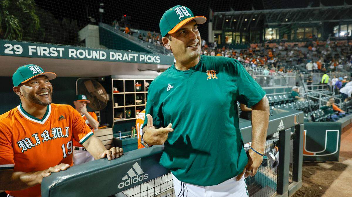 Miami Hurricanes head coach J.D. Arteaga, at right, speaks with assistant coach Chris Dominguez, at left, before the game against Niagara University at Alex Rodriguez Park at Mark Light Field on the University of Miami Campus in Coral Gables, Florida on Friday, February 14, 2025.