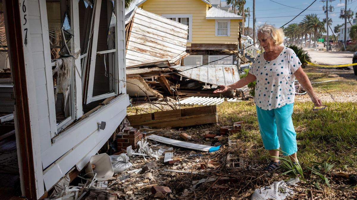 Nancy Hodges Duduen, 83, in front of her childhood home damaged by Hurricane Helene in 2024.
