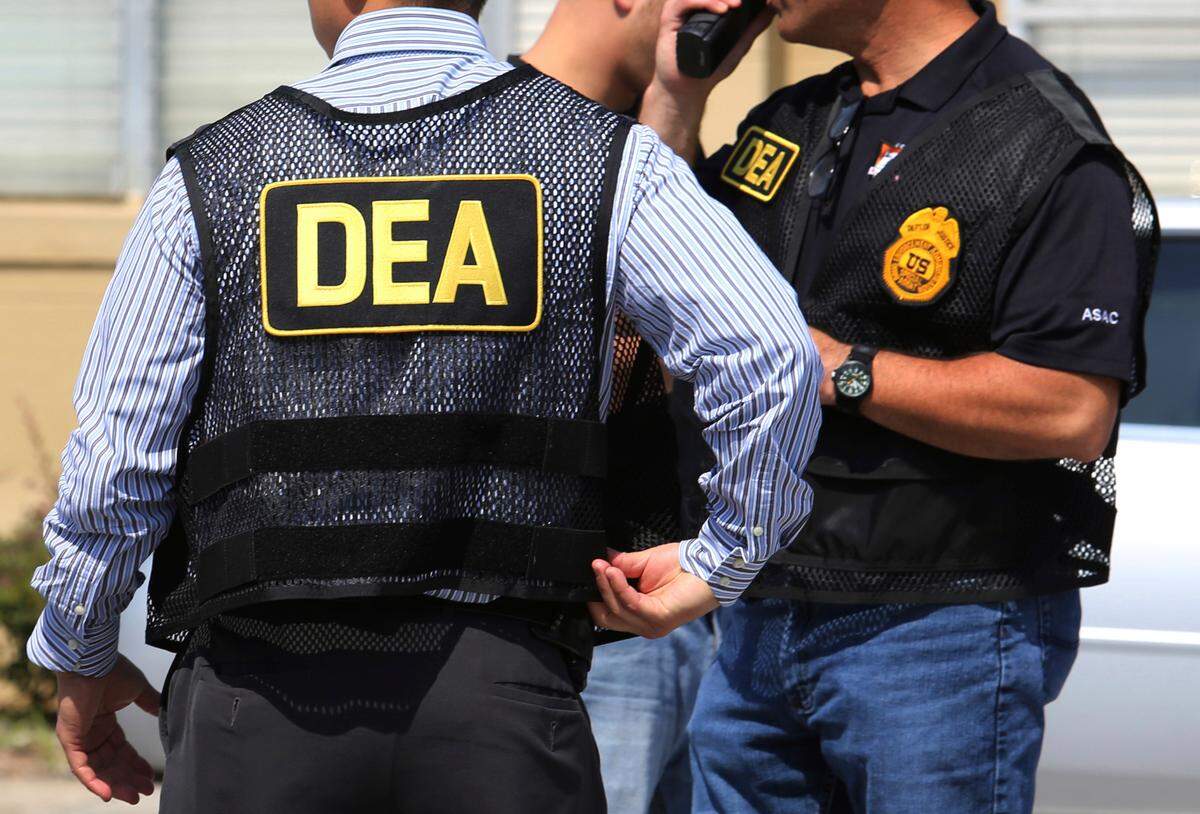 In this June 13, 2016, file photo, Drug Enforcement Administration agents arrive on the scene of a fatal shooting.