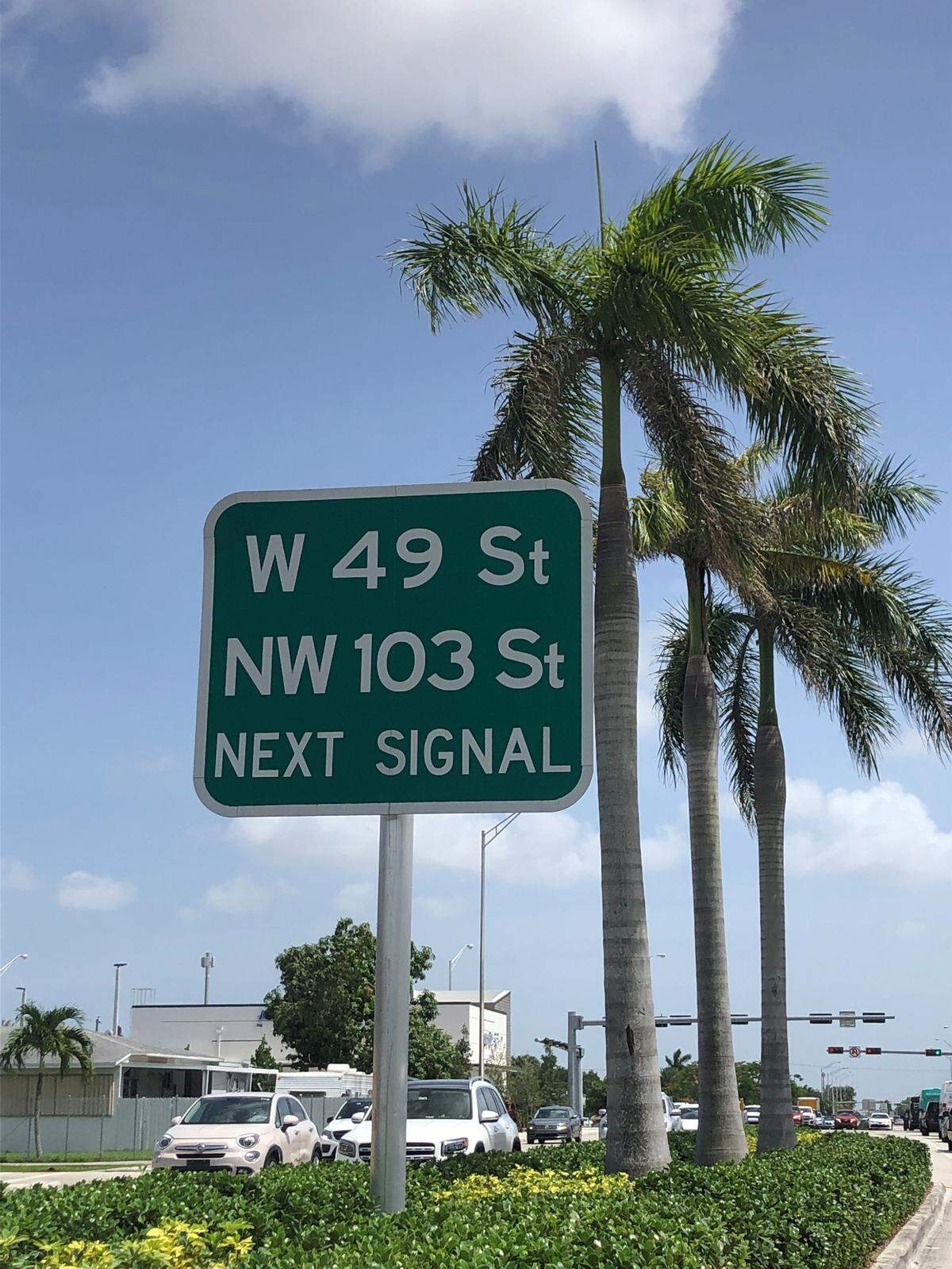 A street sign indicates that West 49th Street in Hialeah — Northwest 103rd Street in Miami-Dade — is near.