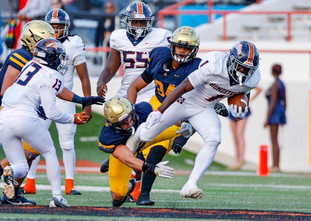 Homestead Broncos Isaac Brown (1) carries the ball during the first half as St. Thomas Aquinas Nicholas Rodriguez (5) attempts to make the stop in the Class 3M state championships at Bragg Memorial Stadium in Tallahassee, Florida, on Saturday, December 9, 2023.