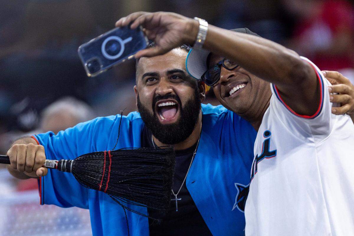 Miami Marlins fans react with a broom as the Marlins close out the series against the New York Yankees with a sweep during the ninth inning of an MLB game at loanDepot park on Sunday, August 3, 2025, in Miami, Fla.