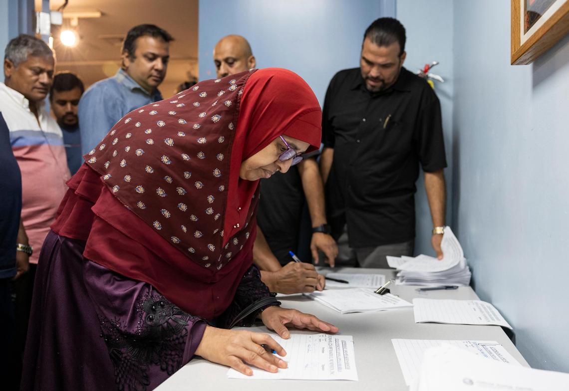 Shamima Siddique signs in to a public zoning meeting at the South Dade Regional Library on Tuesday, Nov. 12, 2024, in Miami, Fla. The meeting, which was postponed due to a lack of quorum, was set to discuss a proposed Muslim cemetery site in the Redlands.