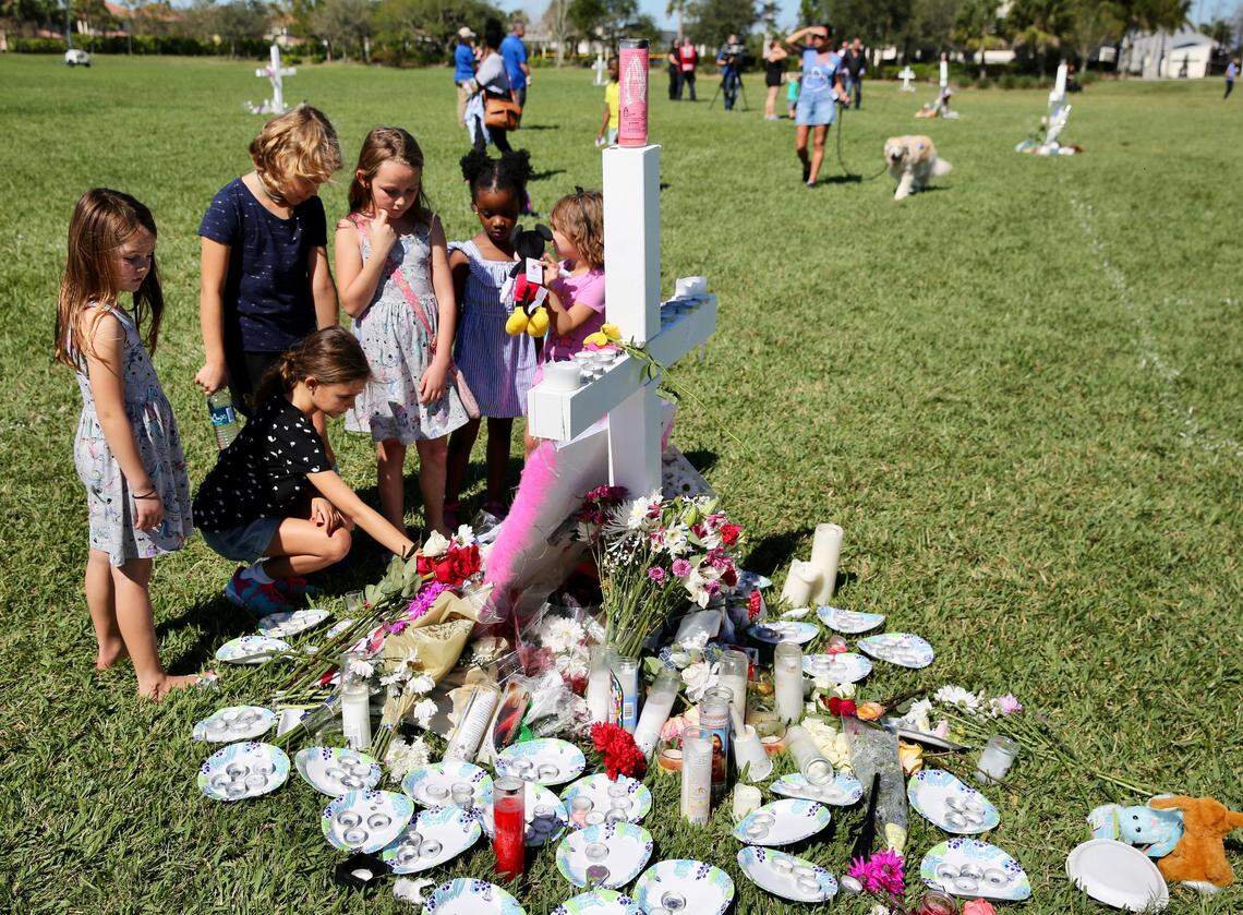 Young children pay homage to the 17 people who were shot and killed at Marjory Stoneman Douglas High in Parkland. They gathered at a memorial at Pine Trails Park in Parkland on Friday, Feb. 16, 2018, two days after the shooting.