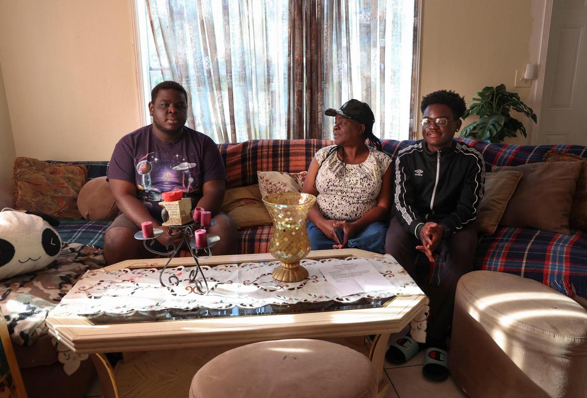 Marie Honor, center, and two of her four children, Mardochee Pierre, left, 23, and Kervin Lundy, 19, who immigrated from Haiti, pose in their Section 8 home in North Miami on Tuesday, May 17, 2022. It has been three weeks since the family was served 60 day eviction notice because their landlord would be selling the house to someone who is not intending on keeping it as a Section 8 home. The family has no where to go. Honor also pays for accommodations in a care home for her daughter, Jenny Pierre, so she is essentially responsible for two rental payments.