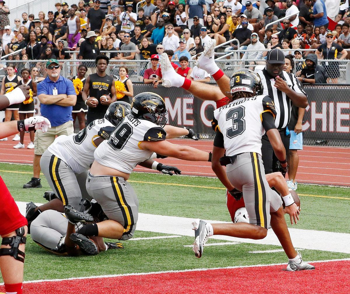 American Heritage Patriots defenders tackle Cardinal Gibbons Chiefs quarterback Dylan Rizk as he dives for the end zone during Saturday’s game at Cardinal Gibbons HS in Fort Lauderdale. Andrew Uloza / for Miami Herald