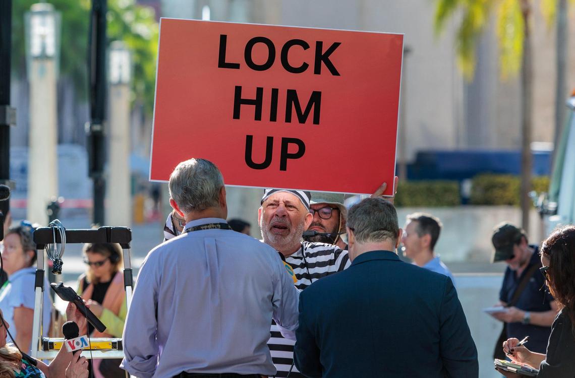 An anti-Trumper holds a sign outside at the Wilkie D. Ferguson Jr. U.S. Courthouse, Tuesday, June 13, 2023, in Miami.