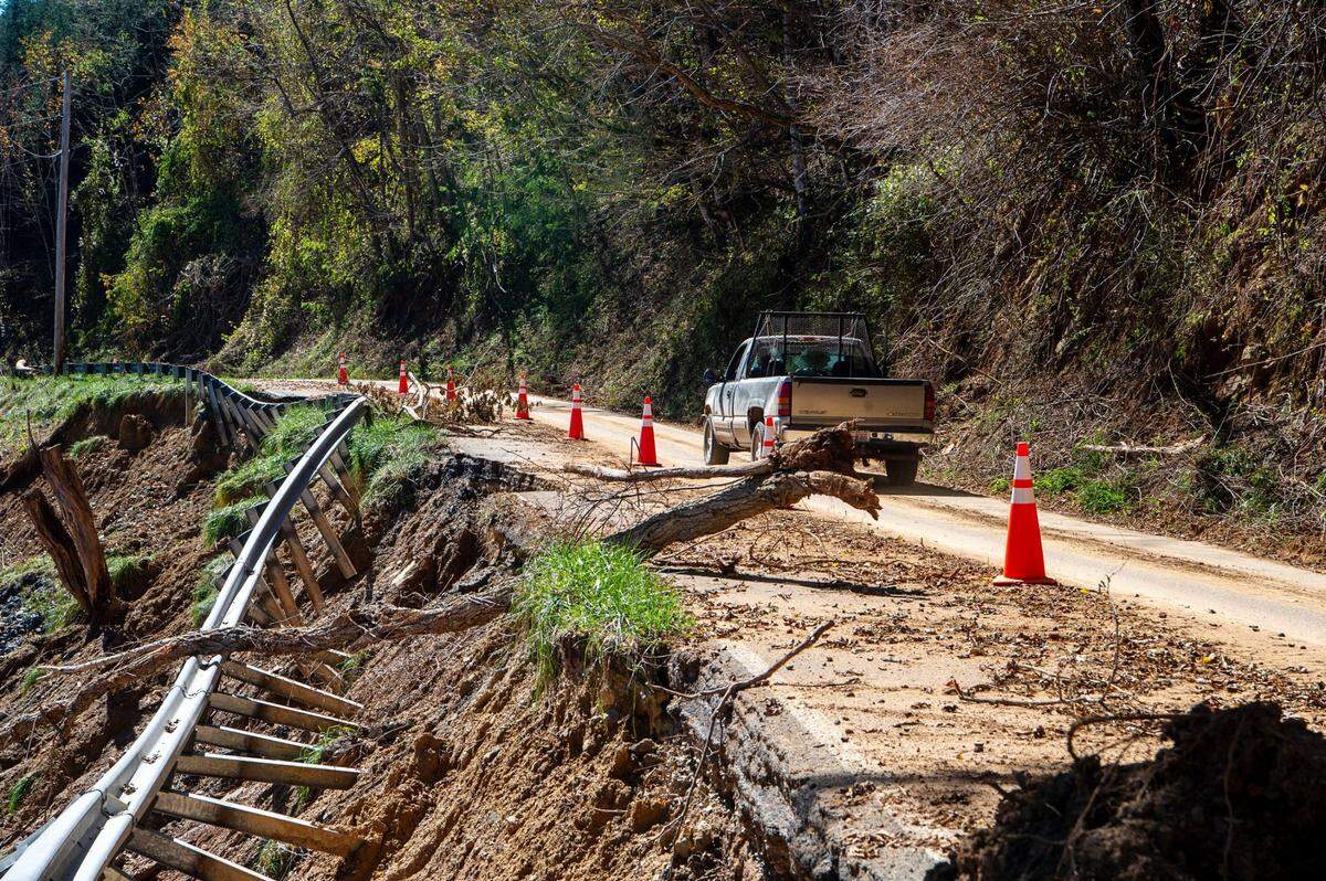 A truck moves along the a damaged road in western North Carolina, where Hurricane Helene’d widespread flooding damages Christmas tree farms.