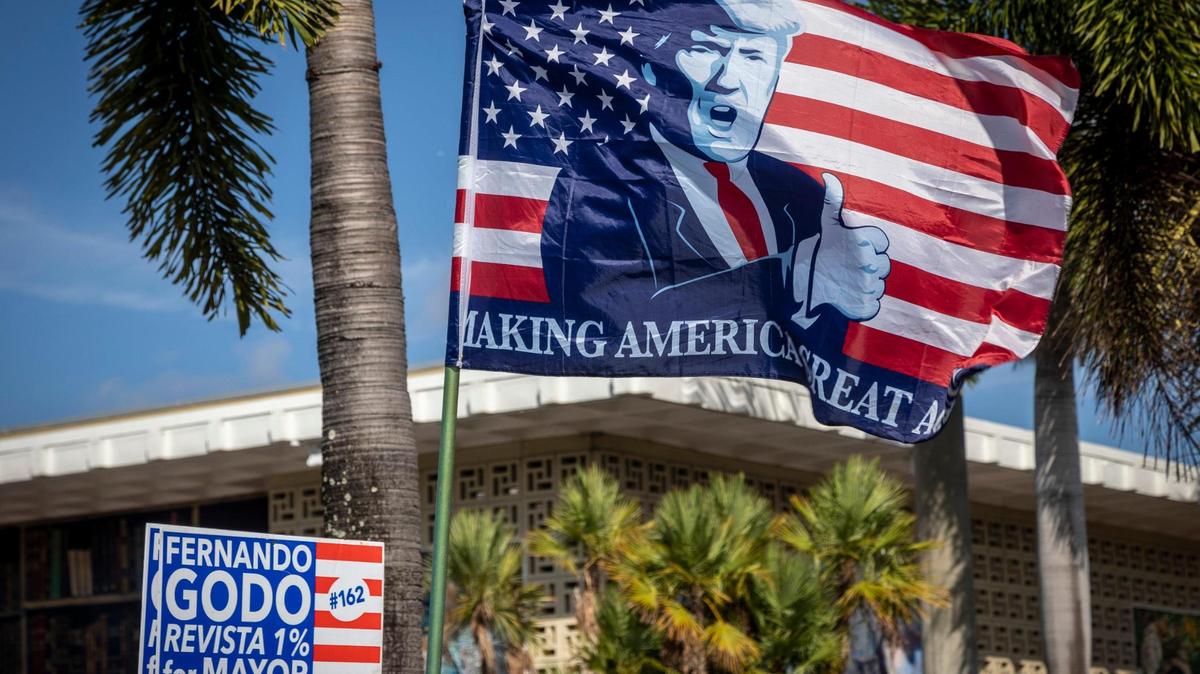 Una bandera con la imagen de Donald Trump decora un camión con carteles del candidato a la alcaldía Fernando Godo en el estacionamiento de la Biblioteca John F. Kennedy en Hialeah durante la votación anticipada, el miércoles 27 de octubre de 2021.