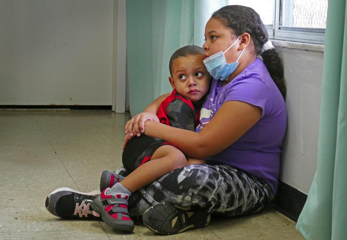 Noelis, 10, comforts her brother, Rafael, 3, at a temporary housing facility run by the Miami Rescue Mission. The siblings, along with their two other sisters and their mother, Lorena Torrente, called the shelter home for a short time, then were moved to another facility. Torrente became homeless during the pandemic, and is in need of housing. Rafael is undergoing testing as they try to determine what is causing a delay in his speech.