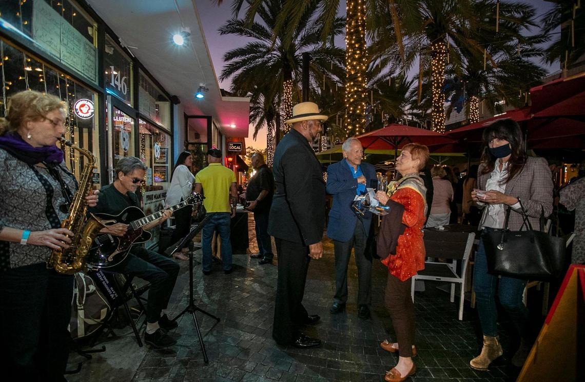 Saxophonist Hana Dolgin and guitarist Eddy Balzola perform as South Florida Professionals hold a networking event at Clutch Burger on Giralda Plaza.