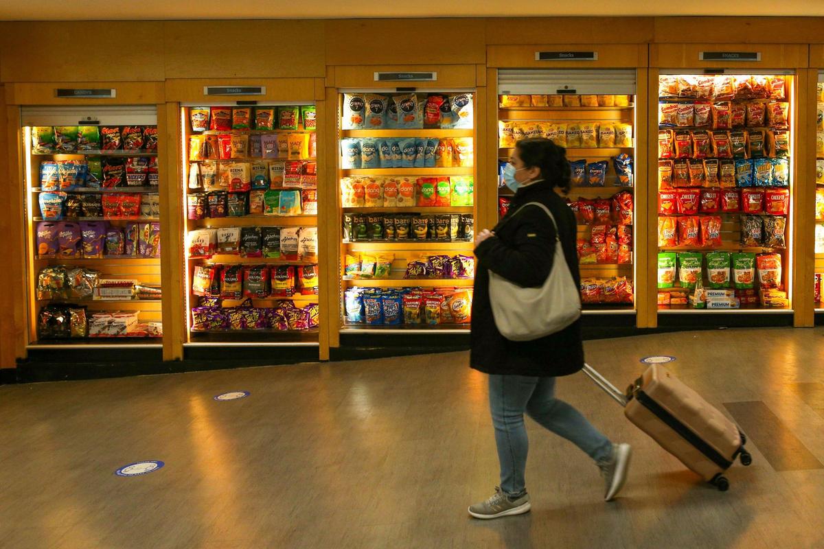A traveler walks past open food shops at Miami International Airport in Miami, Florida, on Monday, Nov. 22, 2021.