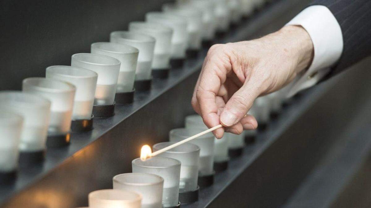 A man lights a candle during an International Holocaust Remembrance Day commemoration in 2018 in Washington, D.C.