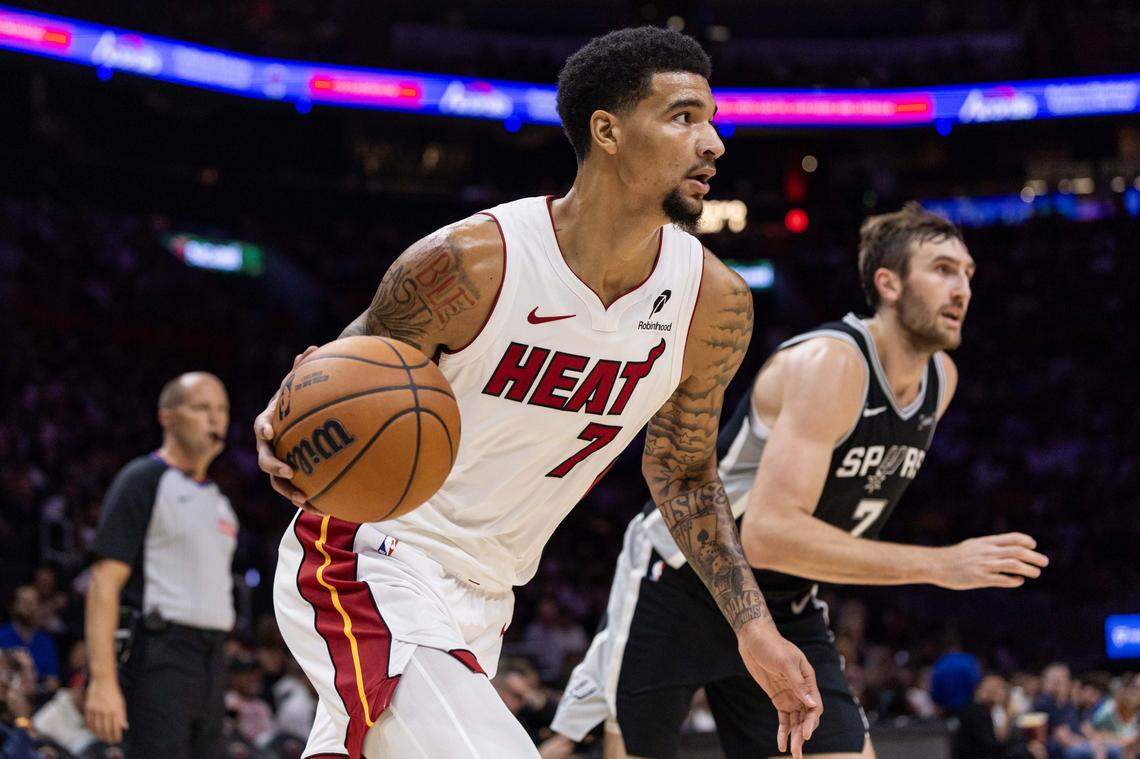 Miami Heat center Kel'el Ware (7) dribbles past San Antonio Spurs center Luke Kornet (7) during the first half of an NBA preseason game at Kaseya Center on October 8, 2025, in Miami.